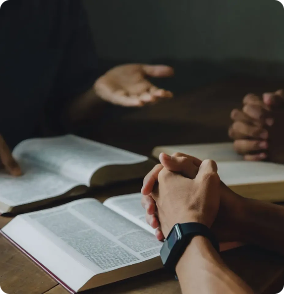 People discussing with open books on table.